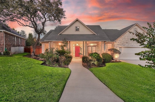 view of front of property with a garage and a lawn