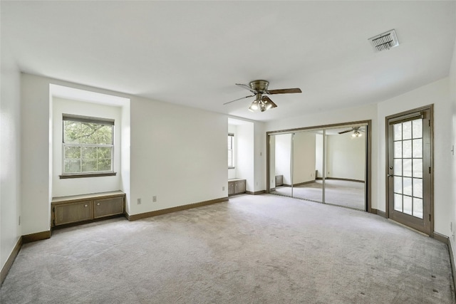 interior space with ceiling fan and light colored carpet