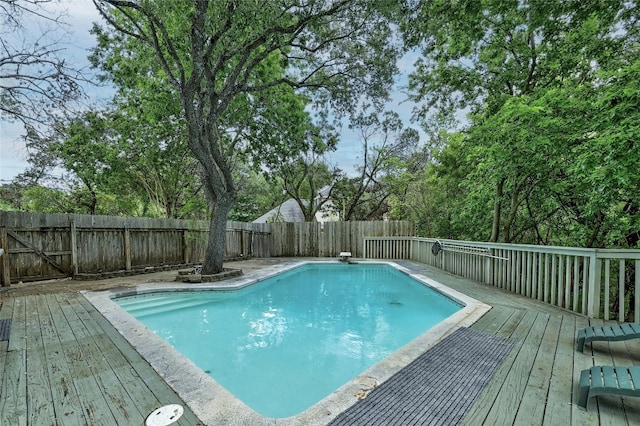 view of swimming pool with a wooden deck and a diving board