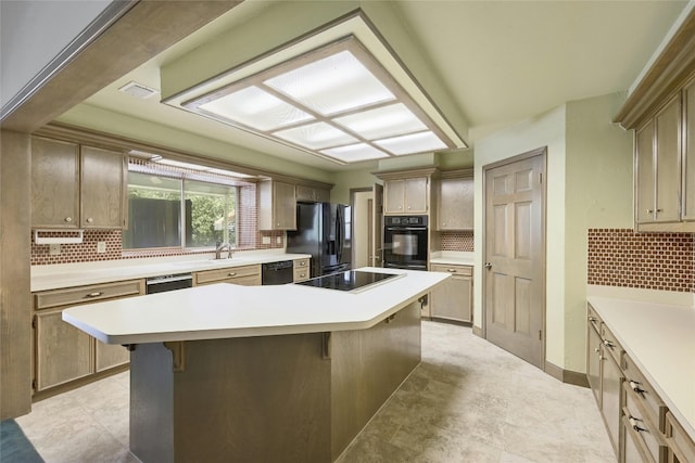 kitchen with a breakfast bar, black appliances, a center island, and backsplash