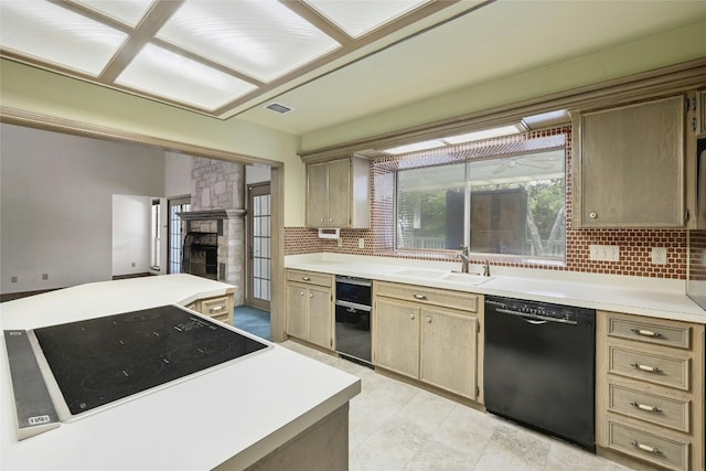 kitchen with light brown cabinets, sink, backsplash, stovetop, and black dishwasher