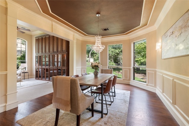 dining area featuring ceiling fan with notable chandelier, dark wood-type flooring, and a healthy amount of sunlight