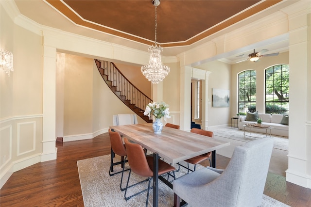 dining room featuring ornamental molding, ceiling fan with notable chandelier, and dark hardwood / wood-style flooring