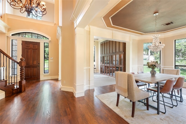 dining space with an inviting chandelier, crown molding, and dark wood-type flooring