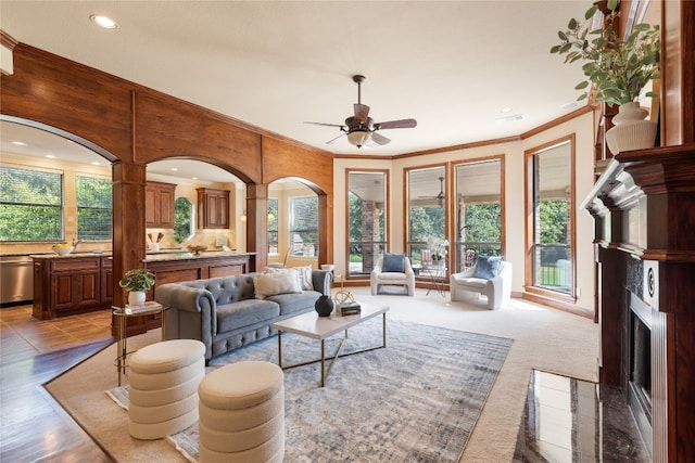 living room featuring ornamental molding, ceiling fan, and plenty of natural light