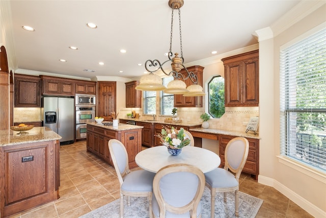 kitchen with tasteful backsplash, a kitchen island, decorative light fixtures, appliances with stainless steel finishes, and a healthy amount of sunlight