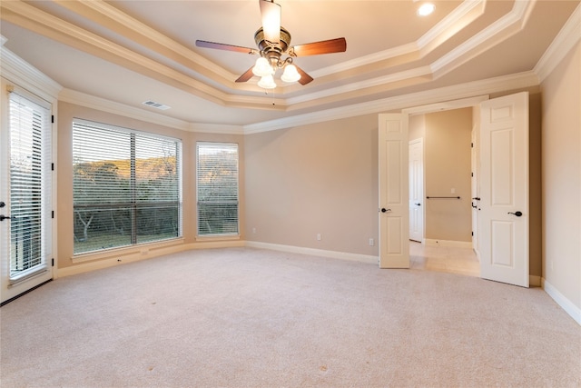 carpeted spare room featuring ceiling fan, a raised ceiling, and crown molding