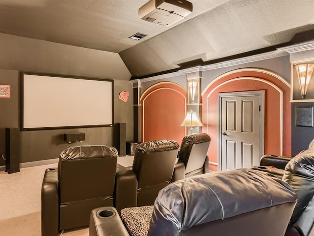 carpeted home theater featuring a textured ceiling, crown molding, and vaulted ceiling