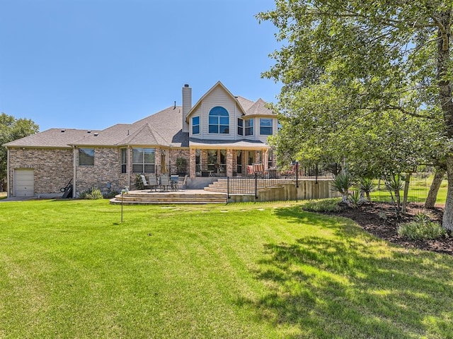 rear view of house featuring a wooden deck and a lawn