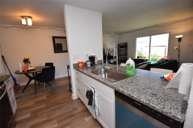 kitchen with white cabinetry, light stone countertops, stainless steel appliances, hardwood / wood-style floors, and sink