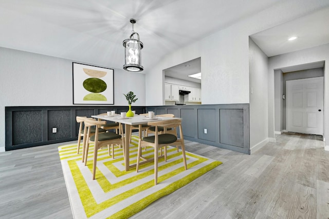 dining space featuring light hardwood / wood-style floors and an inviting chandelier