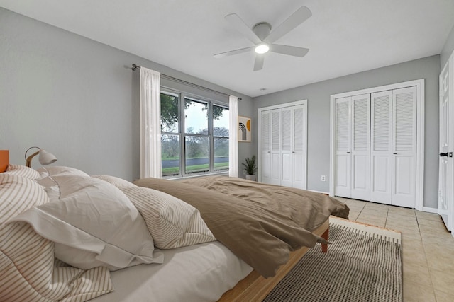 bedroom featuring multiple closets, ceiling fan, and light tile patterned floors