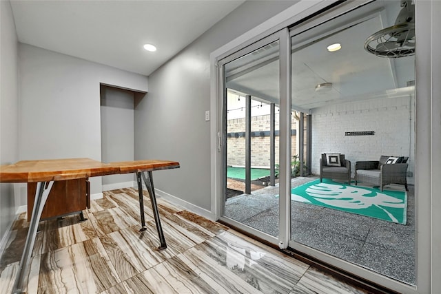 doorway with brick wall and hardwood / wood-style flooring