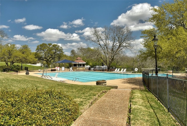 view of swimming pool featuring a yard