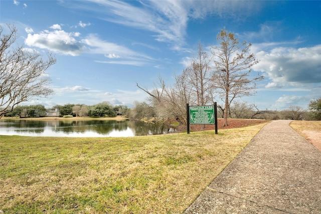 surrounding community featuring a lawn and a water view