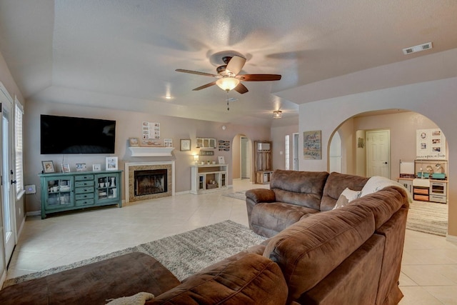 tiled living room featuring ceiling fan and a textured ceiling