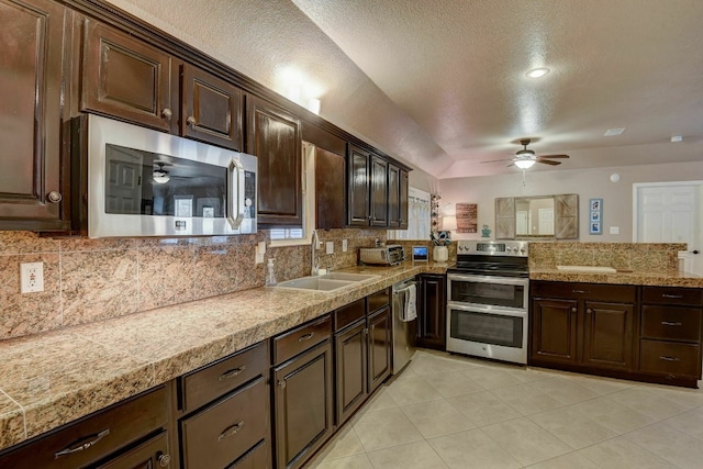 kitchen featuring sink, a textured ceiling, tasteful backsplash, dark brown cabinetry, and stainless steel appliances