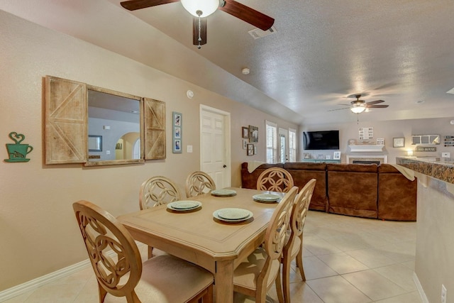 dining space featuring light tile patterned floors, a textured ceiling, and ceiling fan