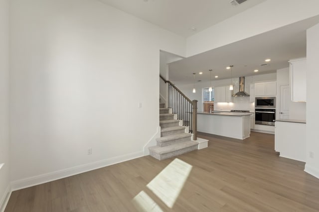 unfurnished living room with sink and light hardwood / wood-style flooring