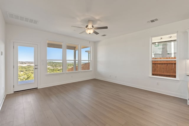 empty room with ceiling fan and light wood-type flooring