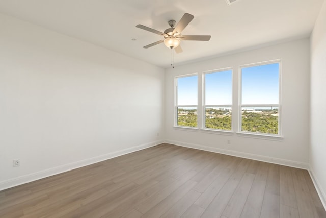 empty room with hardwood / wood-style floors and ceiling fan