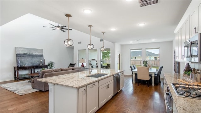 kitchen with dark wood-type flooring, a kitchen island with sink, sink, white cabinetry, and stainless steel appliances