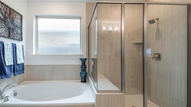 bathroom featuring separate shower and tub