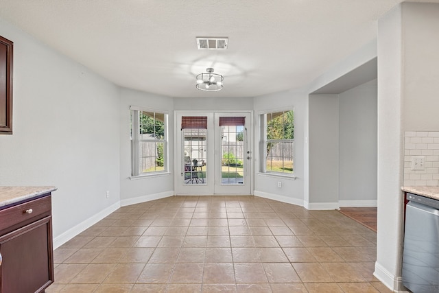 unfurnished dining area with light tile patterned floors and a chandelier