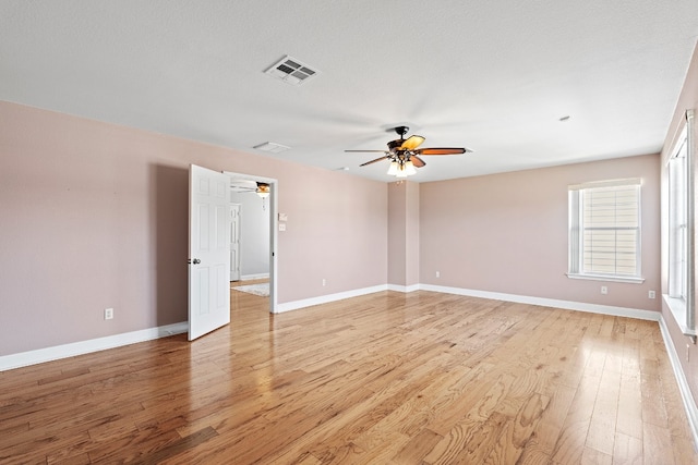 empty room featuring ceiling fan, a textured ceiling, and light hardwood / wood-style flooring