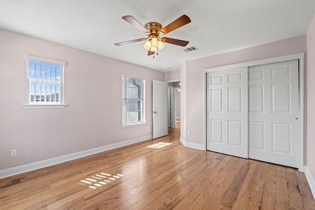 unfurnished bedroom featuring multiple windows, light hardwood / wood-style floors, and ceiling fan