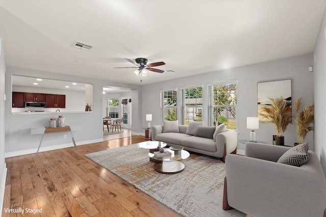 living room featuring ceiling fan and light hardwood / wood-style flooring