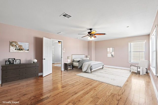 bedroom with a textured ceiling, ceiling fan, and hardwood / wood-style flooring