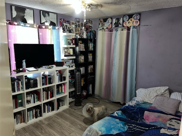 bedroom with a textured ceiling and hardwood / wood-style floors