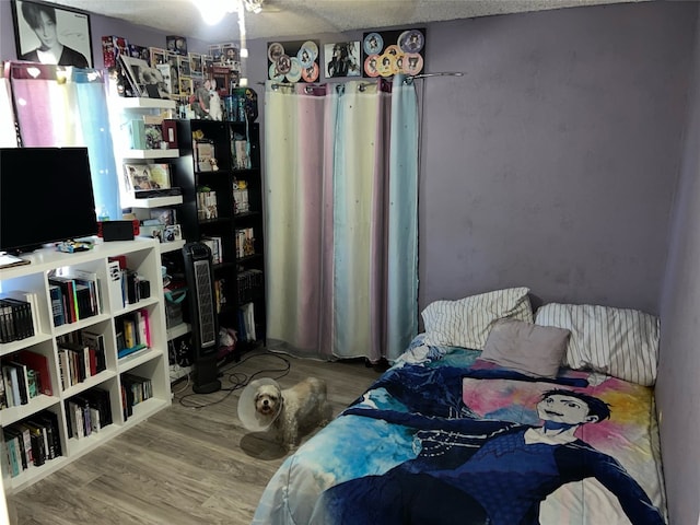 bedroom featuring a textured ceiling and hardwood / wood-style flooring