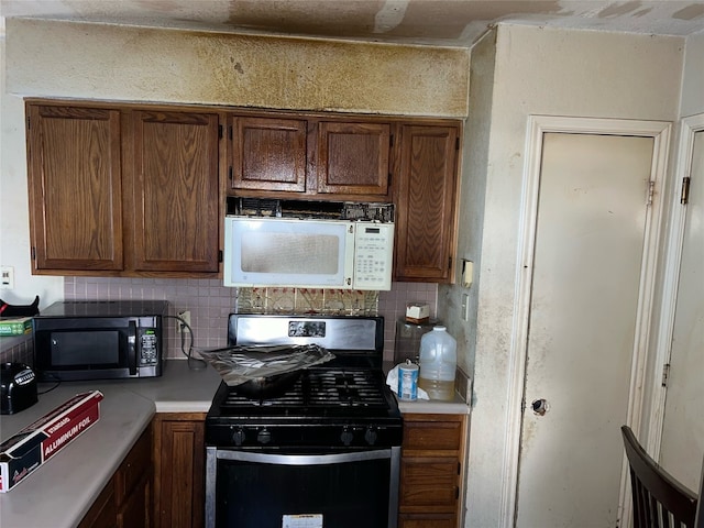 kitchen with stainless steel appliances and decorative backsplash