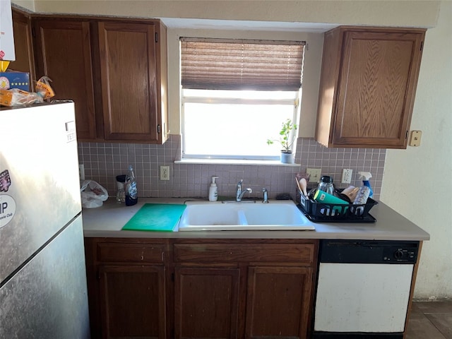 kitchen with stainless steel fridge, backsplash, dishwasher, and sink