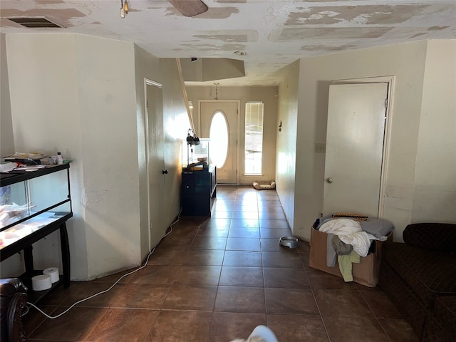 foyer featuring dark tile patterned floors