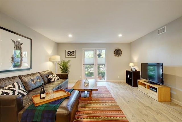 living area featuring light wood-type flooring, baseboards, visible vents, and recessed lighting