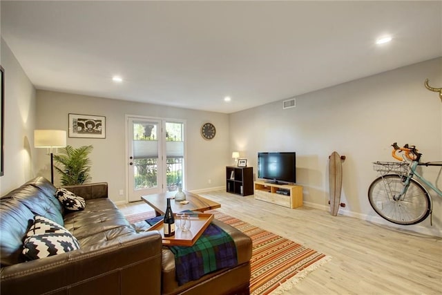 living room featuring baseboards, recessed lighting, visible vents, and light wood-style floors