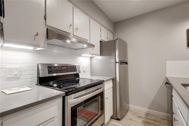 kitchen featuring appliances with stainless steel finishes, white cabinetry, under cabinet range hood, and decorative backsplash