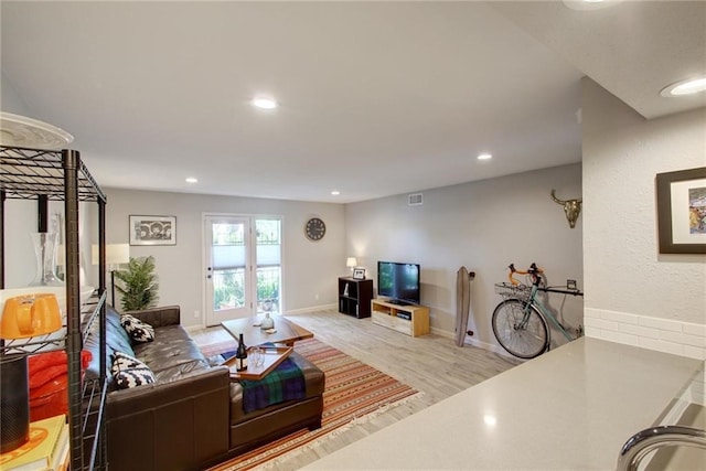 living area featuring baseboards, wood finished floors, and recessed lighting