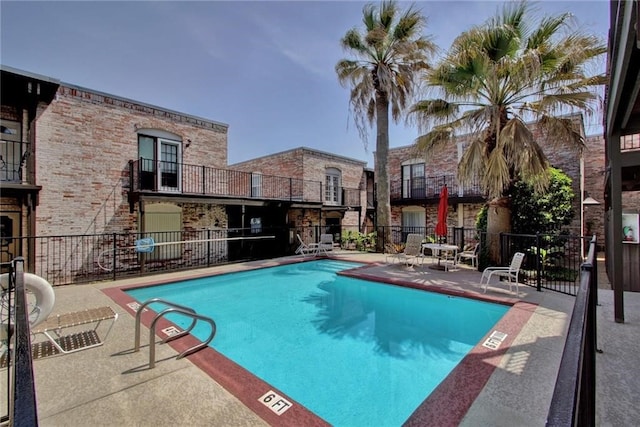 community pool featuring a patio and fence