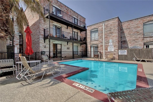 community pool featuring a patio area and fence