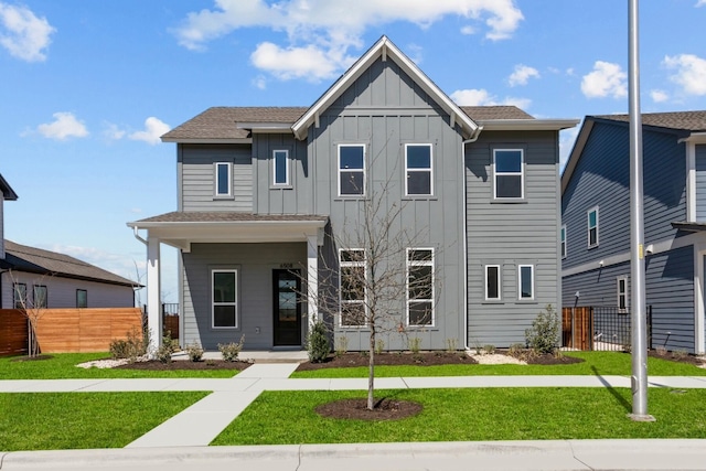 view of front of house featuring board and batten siding, a front yard, and fence