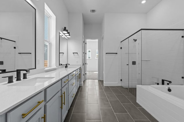 full bath featuring a shower stall, double vanity, visible vents, and a sink