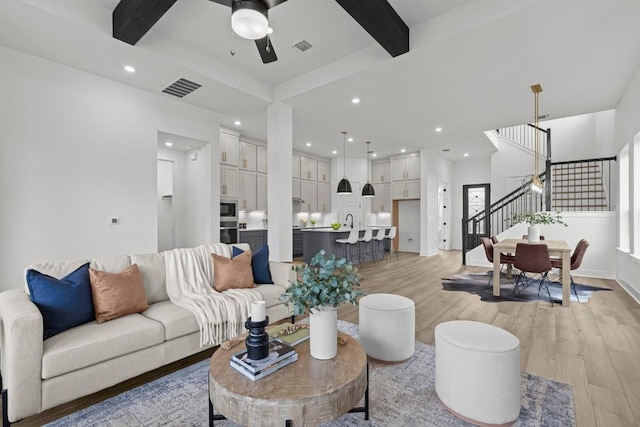 6508 Cowman Way, Austin, TX 78747 - living area featuring light wood-type flooring, stairs, ceiling fan, recessed lighting, and beam ceiling