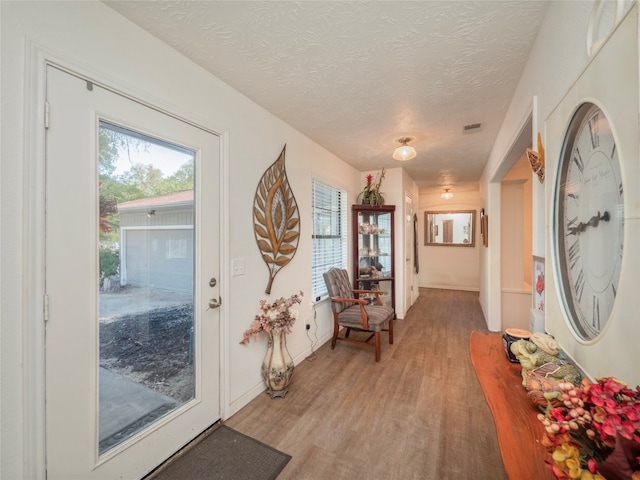 entrance foyer with light wood-type flooring and a textured ceiling