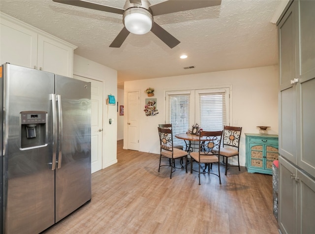 dining area featuring ceiling fan, a textured ceiling, and light wood-type flooring