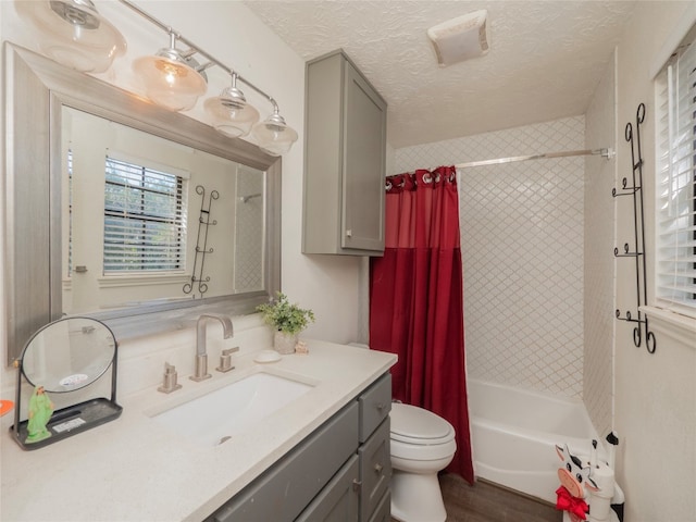 full bathroom with vanity, wood-type flooring, a textured ceiling, shower / bath combo with shower curtain, and toilet