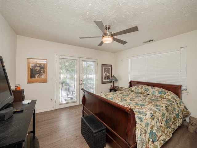 bedroom with ceiling fan, hardwood / wood-style flooring, access to outside, and a textured ceiling